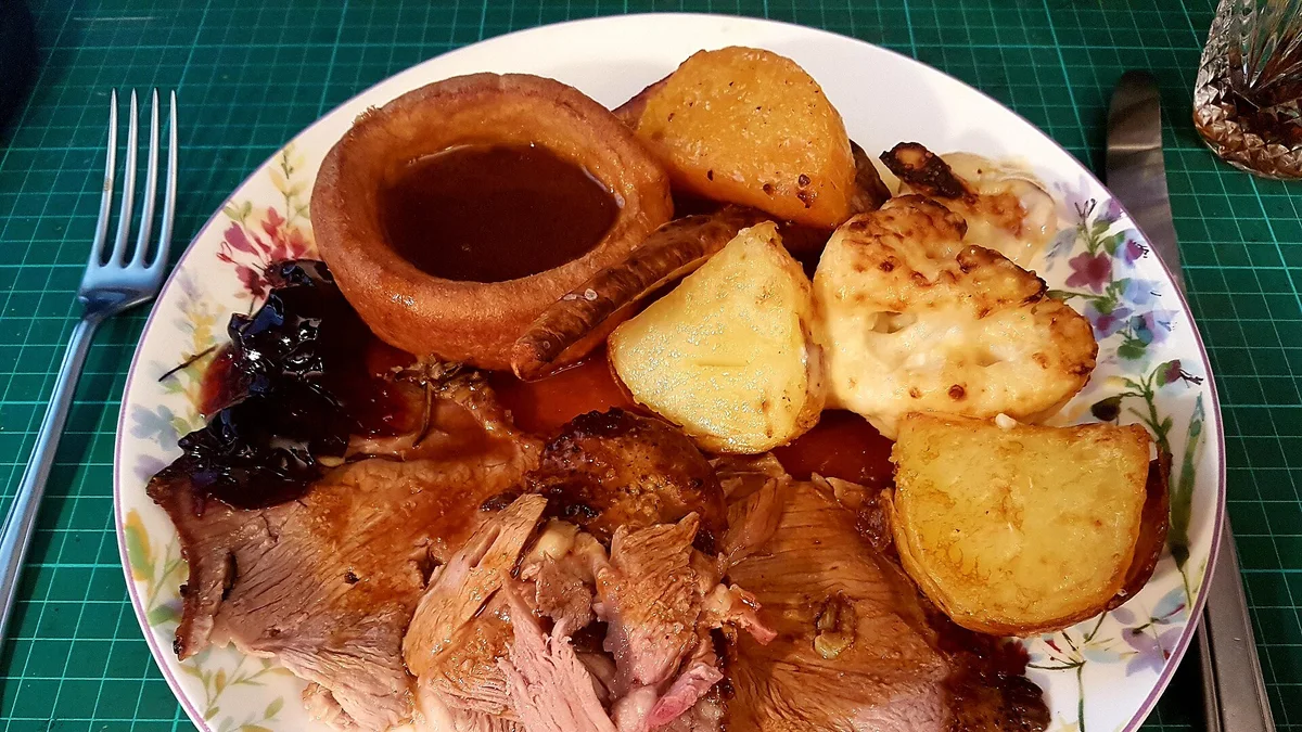 Tranches d'agneau rôti servies avec pommes de terre et légumes