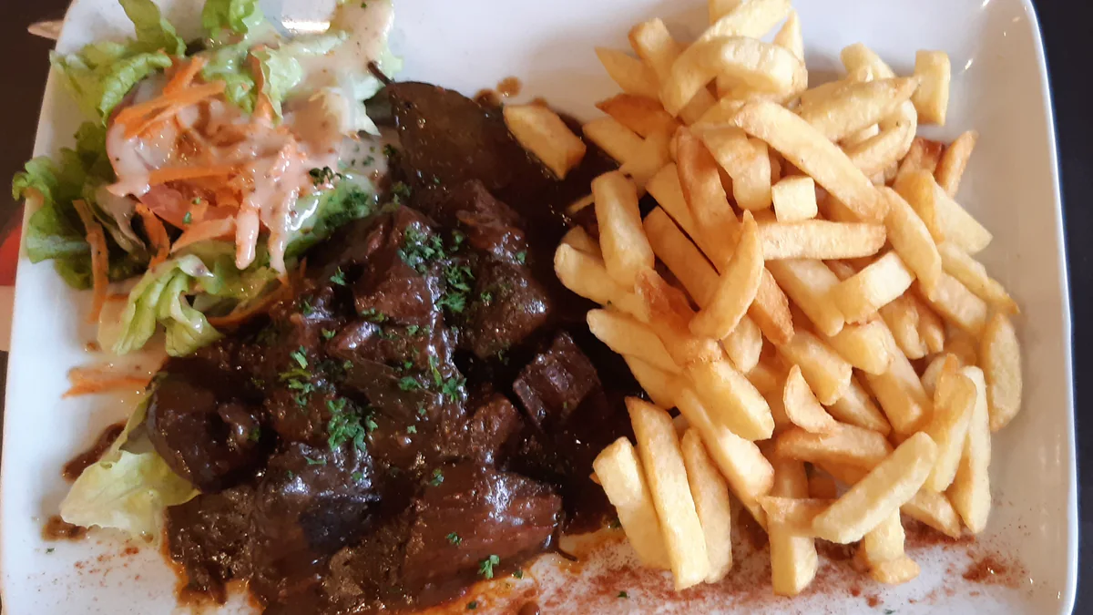 Carbonade flamande servie avec des frites et une salade