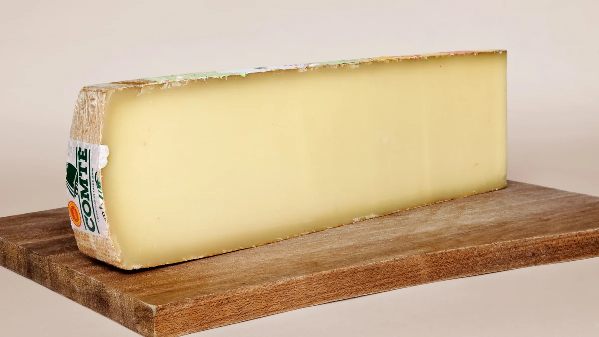 Morceau de comté AOP posé sur une planche en bois
