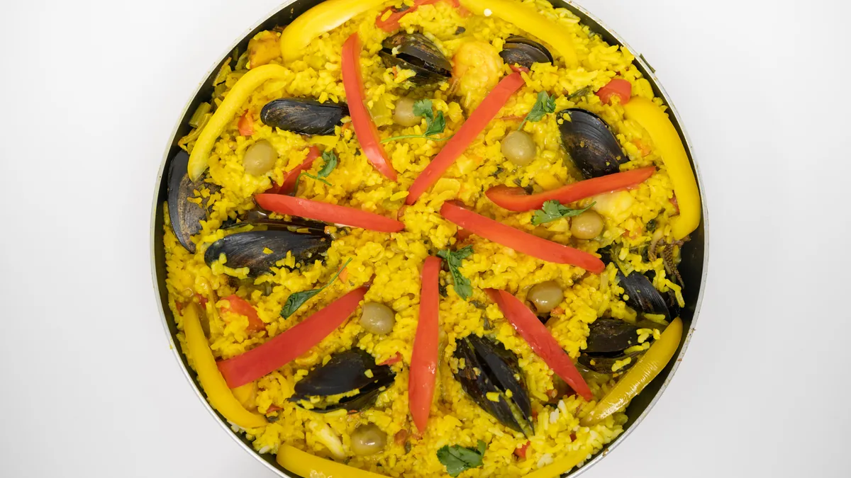 Paella aux fruits de mer garnie de moules et de lanières de poivron rouge