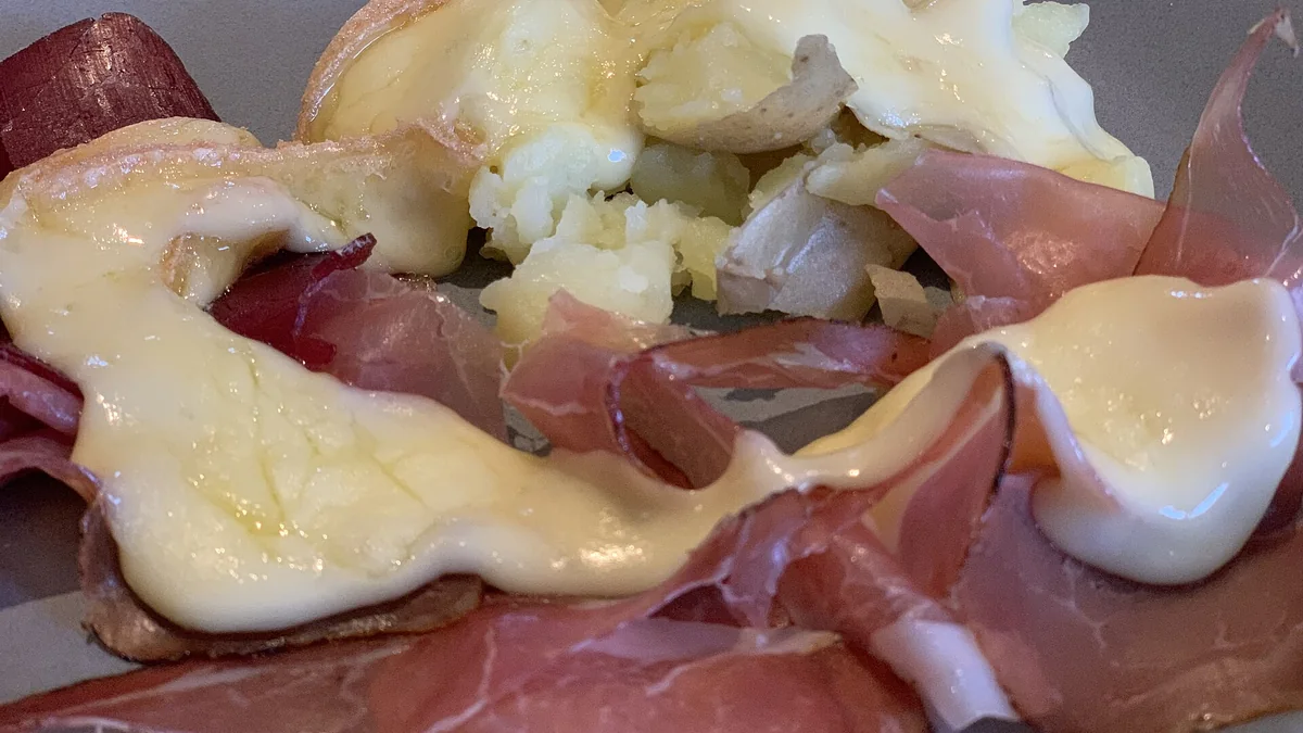Fromage à raclette fondu sur pommes de terre et charcuterie