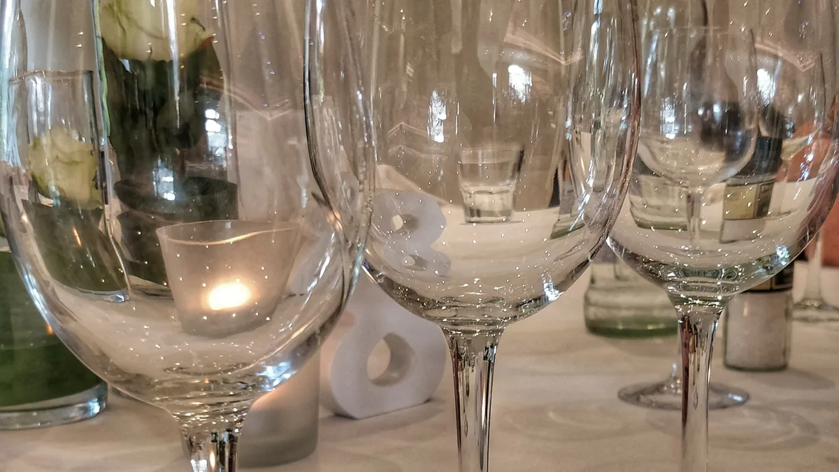 Plusieurs verres à pied transparents disposés sur une table de dégustation